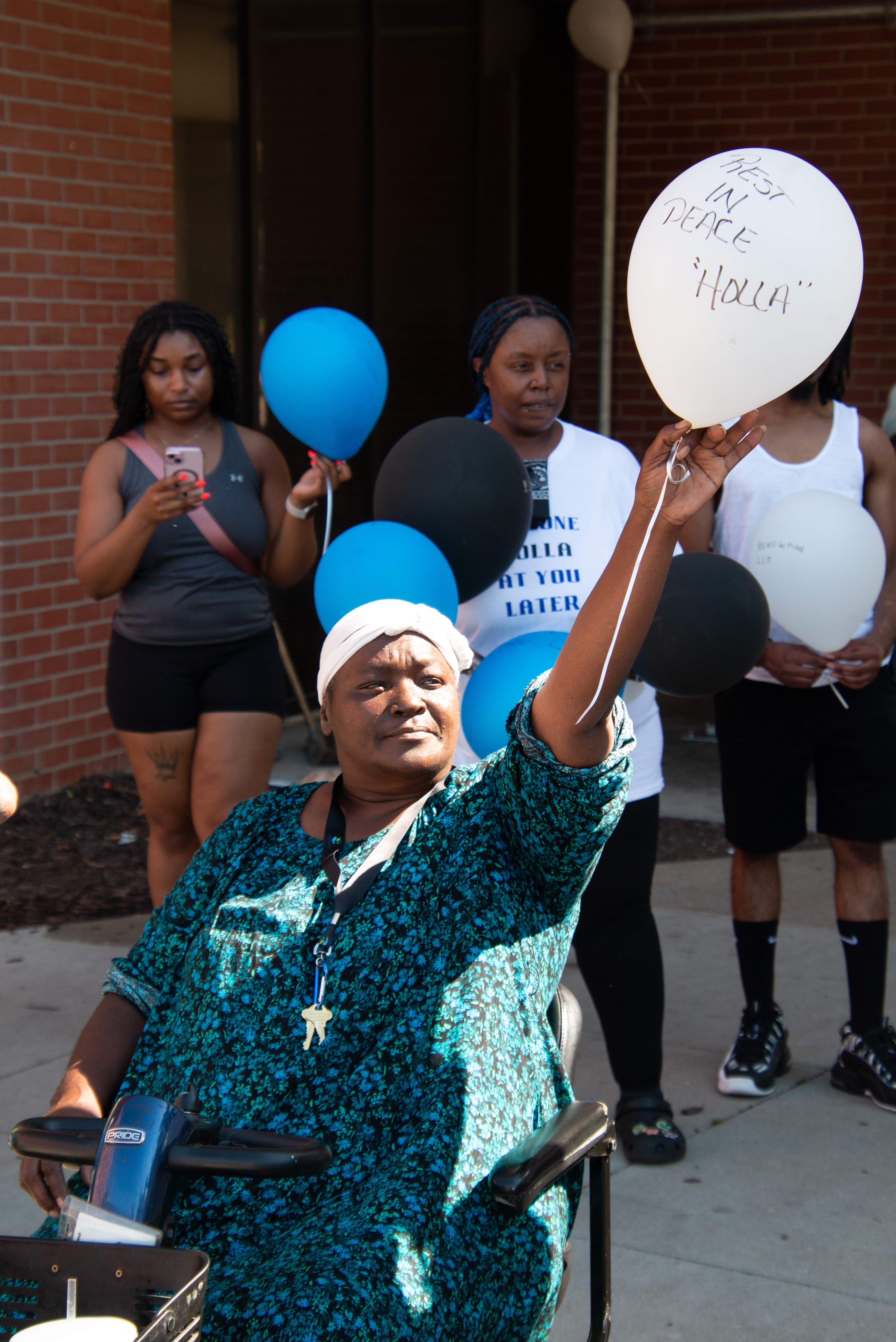 Sandra Dunkin, a resident of Underwood Tower in central Omaha, prepares to release a balloon during an August tribute to her former neighbor Pedtro Chappell. Friends called Pedtro “Holla” in reference to his catchphrase “I’ll holla at ya later.”<br />(Jeremy Turley / Flatwater Free Press)