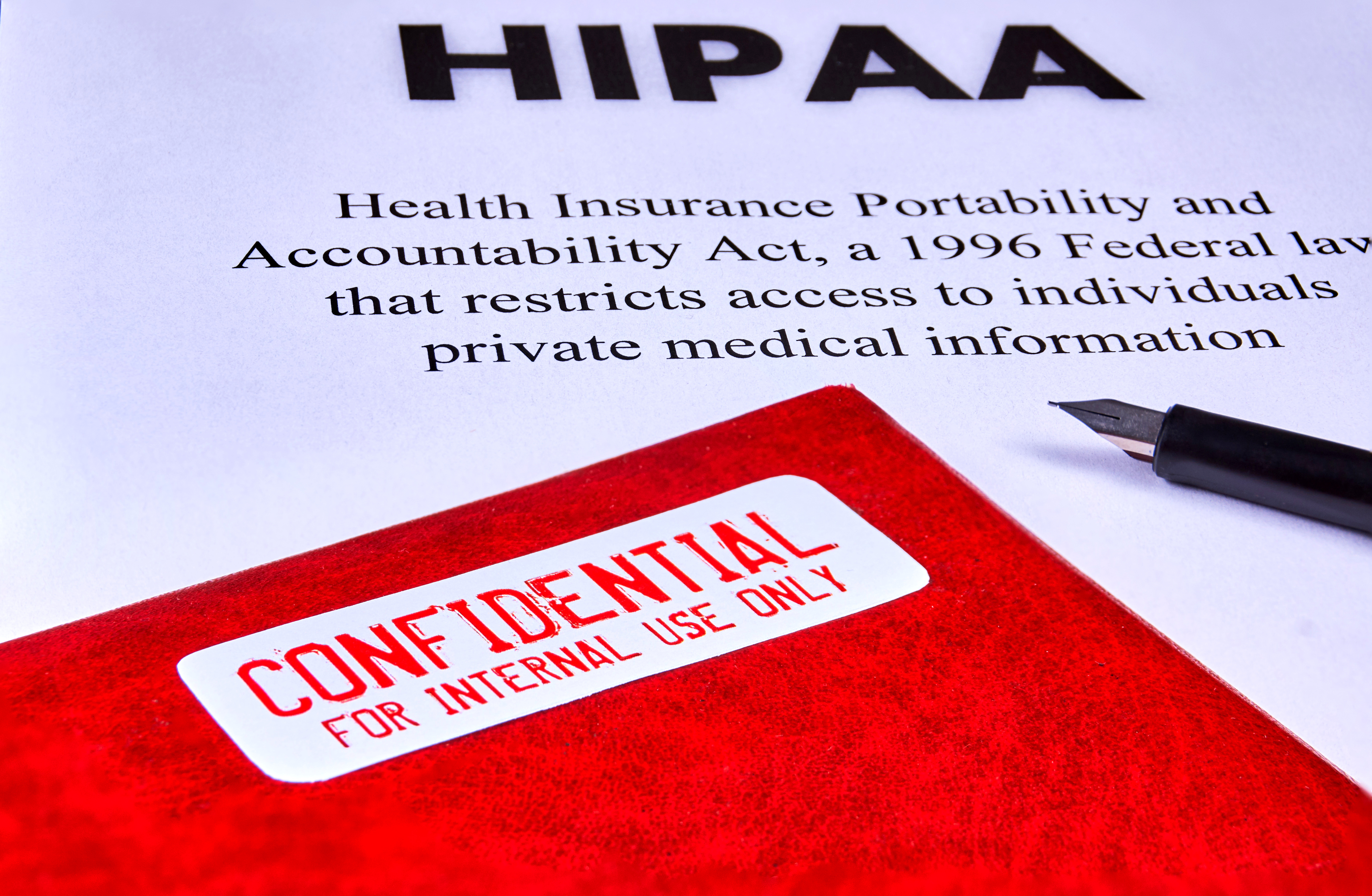 Health Insurance Portability and Accountability Act (HIPAA), red folder with inscription confidential and pen.<br />(Shutterstock)