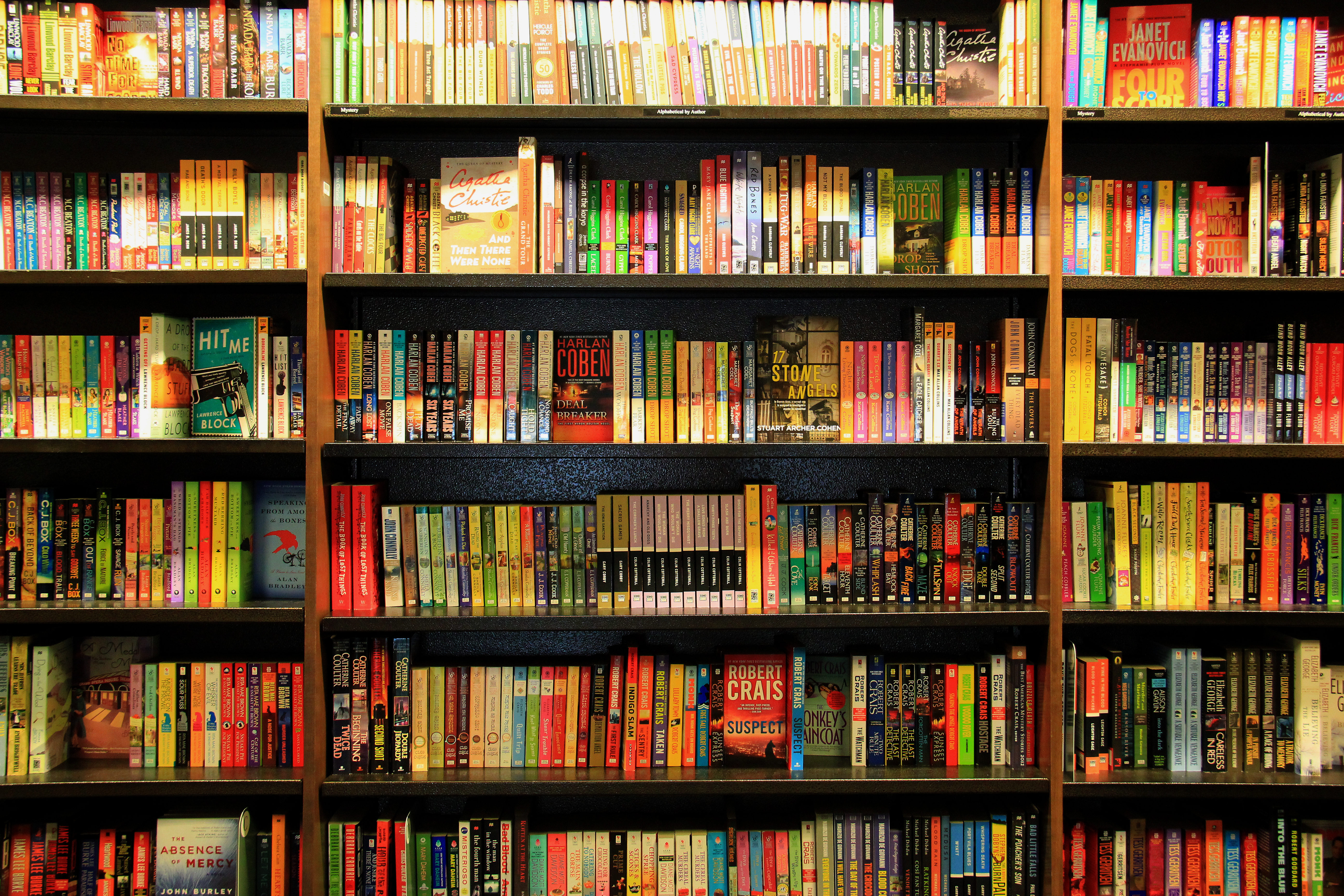 Many different books are arranged in order on wooden bookcases<br />(Shutterstock)