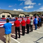 A dedication event for the Dunham House in Omaha, a long-term assisted living facility for veterans severely maimed in combat, kicked off Friday with a flag ceremony. The 30-unit residential complex is in the background.
(Cindy Gonzalez / Nebraska Examiner)