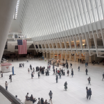 Two large American flags hang within The Oculus in the World Trade Center in downtown Manhattan on September 11, 2026.
(Shalina Chatlani / Stateline)
