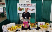 Sheldon Hawkins poses for a photo at his Fruit@MyOffice booth at a trade fair apporximately 5 years ago. Fruit@MyOffice offers a basket program that provides fruit and snacks to your employees. A professional from Fruit@MyOffice will deliver your fruit anywhere in the Omaha Metropolitan area on a weekly, biweekly or monthly basis. (Courtesy of Fruit@MyOffice)