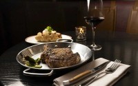 A bone in ribeye and a loaded baked potato are standards of the dinner menu at the Committee Chophouse. 
(Ryan Soderlin / Flatwater Free Press)