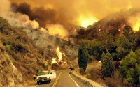 Members of the U.S. Forest Service slowly make their way down Glendora Mountain Road while setting backfires along a containment line to rob the wild fire of fuel Monday, Sept. 23, 2002 in Angeles National Forest north of Glendora, California.
(AP Photo / Ric Francis)