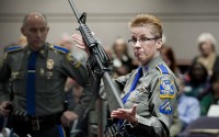 Firearms training unit Detective Barbara J. Mattson, of the Connecticut State Police, holds a Bushmaster AR-15 rifle, the same make and model used by Adam Lanza in the 2012 Sandy Hook School shooting. Neither a gun enthusiast nor a right-wing ideologue, Richard Dyke used political connections and lobster giveaways to build Bushmaster, the company that popularized assault-style rifles.
(Jessica Hill / AP Photo)