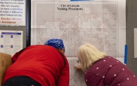 Terri Rotolo Hatch (right) helps a voter find their voting location at the Union at the University of Nebraska on Tuesday, May 10, 2022, in Lincoln, Neb. 
 (Kenneth Ferriera / Lincoln Journal Star via AP)