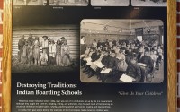 Photos of students in a classroom are seen on display in a museum at the former Genoa Indian Industrial School, Thursday, Oct. 27, 2022, in Genoa, Neb. For decades the location of the student cemetery, where over 80 Native American children are buried, has been a mystery, lost over time after the school closed in 1931 and memories faded of the once-busy campus that sprawled over 640 acres in the tiny community of Genoa. (Charlie Neibergall / AP Photo)