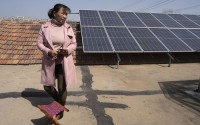 Farmer Shi Mei walks near solar panels on her rooftop in the rural outskirts of Jinan in eastern China's Shandong province on March 21, 2024. The Shi family is on the leading edge of a solar boom in China, which has long dominated global solar manufacturing but didn't always install a lot of it at home. She gets paid for every watt of electricity generated. 
(Ng Han Guan / AP Photo)