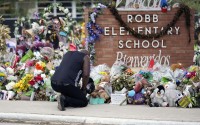 Reggie Daniels pays his respects to a memorial at Robb Elementary School, June 9, 2022, in Uvalde, Texas, created to honor the victims killed in the school shooting. The former Uvalde schools police chief and another former officer have been indicted over their role in the slow police response to the 2022 massacre in a Texas elementary school that left 19 children and two teachers dead, according to multiple reports Thursday, June 27, 2024. 
(Eric Gay / AP Photo)