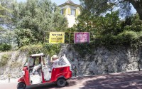 A person dressed as movie character Captain Jack Sparrow steers a tuk-tuk with tourists past Martinho de Almada Pimentel's mountainside mansion Casa do Cipreste, in Sintra, Portugal, Friday, Aug. 9, 2024.
 (Ana Brigida / AP Photo)
