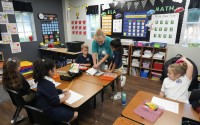 First grade teacher Sharon Parsons (back center) helps her students with a lesson at the Winter Garden Christian Academy Thursday, Aug. 29, 2024, in Winter Garden, Fla.
 (John Raoux / AP Photo)