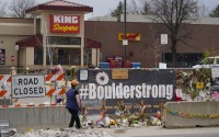 Tributes cover the temporary fence around the King Soopers grocery store in which 10 people died in a mass shooting on April 23, 2021, in Boulder, Colorado. 
(David Zalubowski / AP Photo)