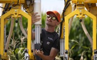 PowerPollen intern Evan Mark prepares a pollen applicator, Thursday, Aug. 22, 2024, near Ames, Iowa. 
(Charlie Neibergall / AP Photo)