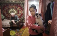 Alina Soboleva, 9, holds her cat "Murchik" at her house in Izium, Ukraine, Dec. 6, 2024. Her grandmother, Svitlana Lokotosh, explains that Alina has been withdrawn since witnessing the deaths of her mother and other grandmother in a shelling in the courtyard of their home. 
(Evgeniy Maloletka / AP Photo)