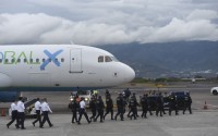 Security personnel approach a plane carrying migrants from Central Asia and India, deported from the United States, at Juan Santamaría International Airport in San Jose, Costa Rica, Thursday, Feb. 20, 2025. 
(Jose Diaz / AP Photo)