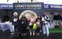 Masako Higuchi, 83 (center) and May DuBois (second from right) take photos with fellow runners ahead of the Los Angeles Marathon at the Lifestyle Expo at Dodger Stadium, Friday, March 14, 2025 in Los Angeles. 
(Damian Dovarganes / AP Photo)