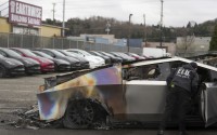 A member of the Seattle Fire Department inspects a burned Tesla Cybertruck at a Tesla lot in Seattle, Monday, March 10, 2025. 
(Lindsey Wasson / AP Photo)