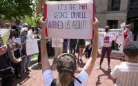 A supporter of Badar Khan Suri holds a sign saying "It's the 1984 George Orwell Warned Us About!," while attending a rally in opposition to the Georgetown University scholar's arrest and detention, outside of the courthouse, at the Federal District Court for the Eastern District of Virginia, in Alexandria, Va., Thursday, May 1, 2025. 
(Jacquelyn Martin / AP Photo)