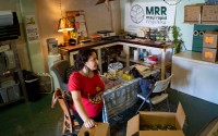 Nicole Huguenin, executive director of Maui Rapid Response, a nonprofit supporting Maui fire survivors with cash assistance, organizes canned food at the organization's warehouse in Kahului, Hawaii, Wednesday, March 4, 2026. 
(Mengshin Lin / AP Photo)