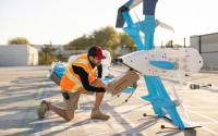 An Amazon employee loads a package into one of the company’s delivery drones. The drones are able to carry packages weighing 5 pounds or less up to 7.5 miles away from their launch site. 
(Photo courtesy of Amazon via Flatwater Free Press)
