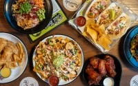 Dishes from the Omaha location of 30Hop include, from top left: an Ahi poke bowl, shrimp tacos, Buffalo wings, nachos and chicken strips.
 (Courtesy photo)