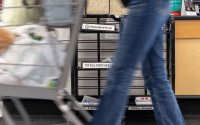 A grocery store shopper passes by a newsstand in Omaha where daily papers sit for sale on Oct. 8, 2025. The Omaha World-Herald and the Lincoln Journal-Star will no longer print a Monday edition starting in early November. 
(Naomi Delkamiller / The Midwest Newsroom)