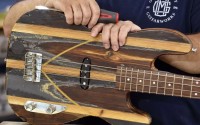 Phil Whitmarsh made this electric bass from decking salvaged from the USS Texas. The patina of the raw wood, primer, sealer and the gray topcoat paint of the ship’s deck are all visible on the instrument’s body.
(Flatwater Free Press)