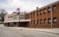 An exterior photo of Weeping Water Public Schools during a recent school day. The school’s 299 students attend classes in this building. This year, they switched to a four-day week after the school struggled to attract and retain teachers. “Smaller schools, we don’t have the financial resources to throw money at people to stay,” said Superintendent Kevin Reiman. “I just can’t compete with those types of things.” (Abiola Kosoko / Flatwater Free Press)
