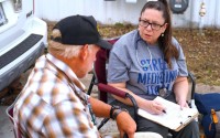Melissa Neuenfeldt listens to Wayne Birkholtz discuss his medical needs and what medication he takes on Sept. 9, 2024. Neuenfeldt met Birkholtz outside his car where he’s currently living. As a nurse with HEAL Omaha, which provides healthcare to Omaha’s unsheltered homeless population, she hopes helping manage their health can create a clearer path toward housing stability. 
(Chris Bowling / Flatwater Free Press)