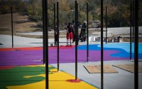 The grounds of outdoor athletic courts at Myott Park in the Bluestem Prairie residential area, which is being developed by Habitat for Humanity Omaha, are transformed into art by Frankie Zombie, a national artist who is videotaping his Omaha experience for a pilot he is developing. He currently is a co-star of the “Artfully Designed” show that is streaming on HBO. Also shown painting is crew member Dante Page. 
(Courtesy of John Melingagio and Habitat for Humanity)