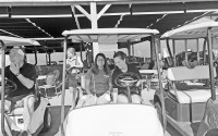A  young lady with a white cane and her golf guide in a golf cart. (Megan Mackie)