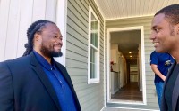 Donell Brown of Lionshead LLC. (left)  talks with Buey Ray Tut, CEO of Spark in the front of one of the newly constructed homes that Brown built in North Omaha. 
(Cindy Gonzalez / Nebraska Examiner)