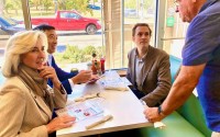 Leaders of the Forward Party,  were in Omaha to show support for nonpartisan candidates. Nick Batter (second from right), a nonpartisan candidate running for District 13 in the Legislature, sits in a booth at Harold’s Koffee House across from Andrew Yang, a 2020 Democratic presidential candidate who founded the Forward Party, and Kerry Healy, former lieutenant governor of Massachusetts who is the party’s executive chair. 
(Cindy Gonzalez / Nebraska Examiner)