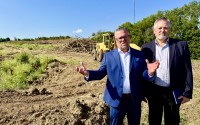 The Bear Creek residential subdivision is to rise on this roughly 40-acre tract in Blair, Nebraska. Left is Jason Thiellen of E&A Consulting Group who also is president of Welcome Home Coalition, a nonprofit who helped push for the CID Act, along with Blair City Administrator Phil Green. 
(Cindy Gonzalez / Nebraska Examiner)
