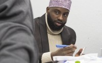Abdikadir Moalim, founder of the Somali Community of Siouxland, speaks with community member Mohammed Ali on Dec. 15, 2024 at the nonprofit’s office. Moalim works as an interpreter at the nearby Tyson plant in Dakota City. 
(Jerry L Mennenga / Flatwater Free Press)