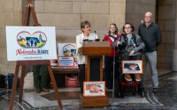 Susan Samuelson (center) leads a rally with Tammy, Derek and Darin Caster, (from left) in the Nebraska State Capitol urging the Nebraska Department of Health and Human Services not to make significant changes to the state’s Aged and Disabled Waiver and Traumatic Brain Injury Waiver, Jan. 14, 2026.  (Zach Wendling / Nebraska Examiner)