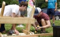 Jack Cicin (left) and Jared Haynes build a wooden bench during a Strong Towns gathering in North Omaha on June 1. The group later placed the benches at bus stops that lacked seating. 
(Jeremy Turley / Flatwater Free Press)