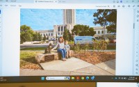 An AI-rendered image of what a proposed sculpture honoring Cameron the Capitol Cat outside the Nebraska State Capitol could look like is projected during a meeting of the Nebraska Capitol Environs Commission on Sept. 25, 2026. The artificial intelligence image is not the final design. The supporters and sculptor Benjamin Victor would design the final work. 
(Zach Wendling / Nebraska Examiner)