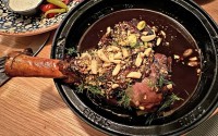 The lamb dish is served tableside in a clay tajine. The bone-in shank is served with pomegranate jus, dill and dukkah, a Middle Eastern condiment consisting of a mixture of herbs, nuts, and spices.
 (Sarah Baker Hansen / Flatwater Free Press)