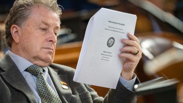 State Sen. Stan Clouse of Kearney reads the voter initiative packet from 2022 that led to voter-approved increases to the state’s minimum wage, March 31, 2025. 
(Zach Wendling / Nebraska Examiner)