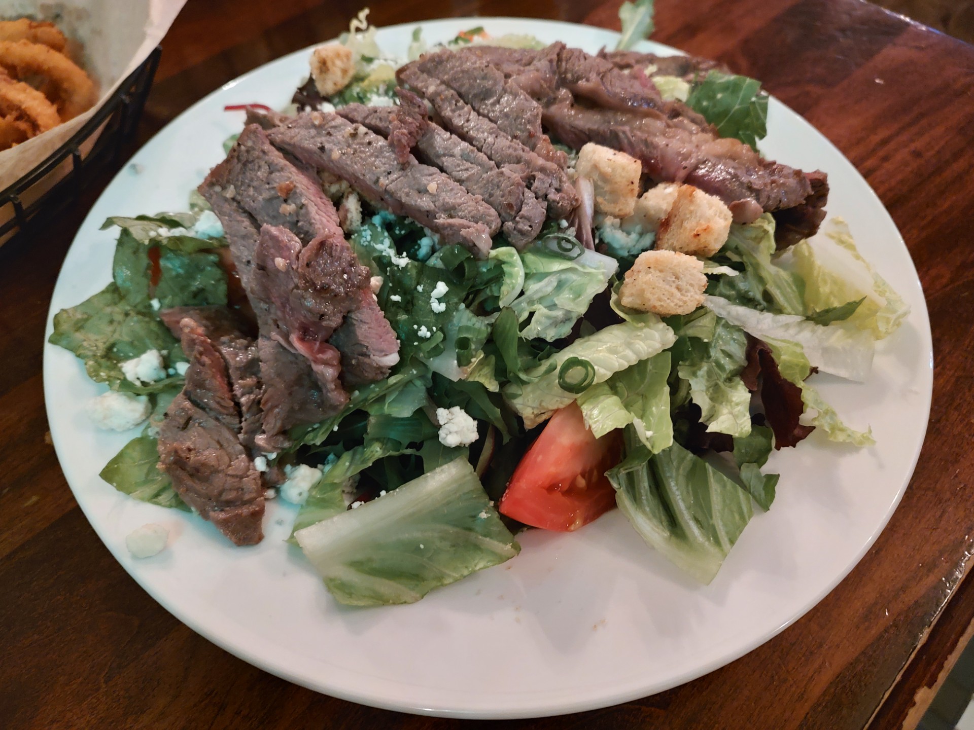 Bleu cheese, healthy greens under a great steak. This plate was huge.<br />(Austin Petak / The Daily Record)