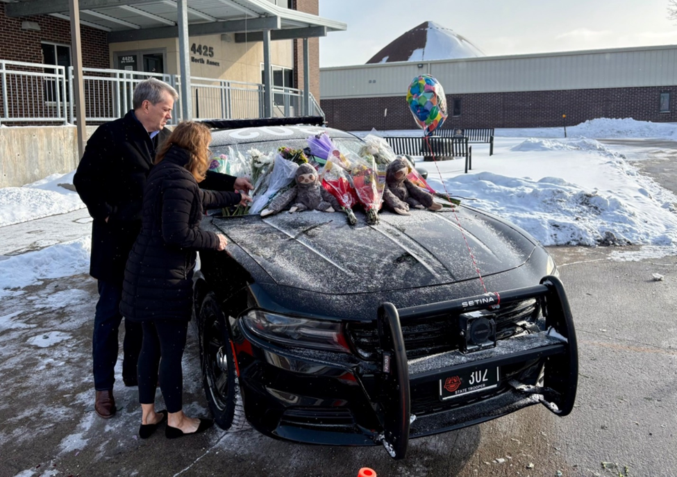 Nebraska Gov. Jim Pillen and First Lady Suzanne Pillen pay their respects at the cruiser of fallen Nebraska State Patrol trooper Kyle McAcy in the Troop A Headquarters parking lot in Omaha.<br />(Courtesy of the Governor’s Office)
