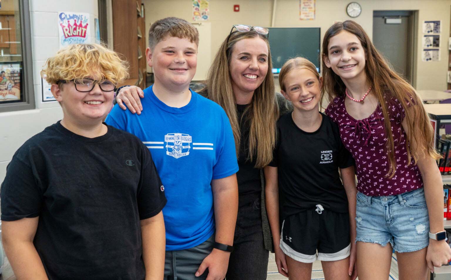 Lindsey Wilson (center) joins four of her seventh grade students at Bennington Middle School after Wilson is named the 2025 Nebraska Teacher of the Year. From left: Carter Nebbia, Spencer Hartig, Abby Iverson and Lucy Hunt, Sept. 19, 2024.<br />(Zach Wendling / Nebraska Examiner)